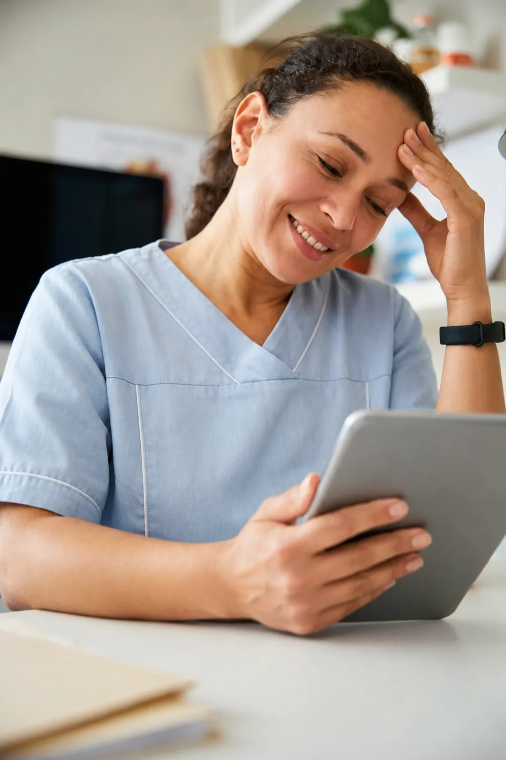 Relaxed dental clinic worker smiling at a tablet